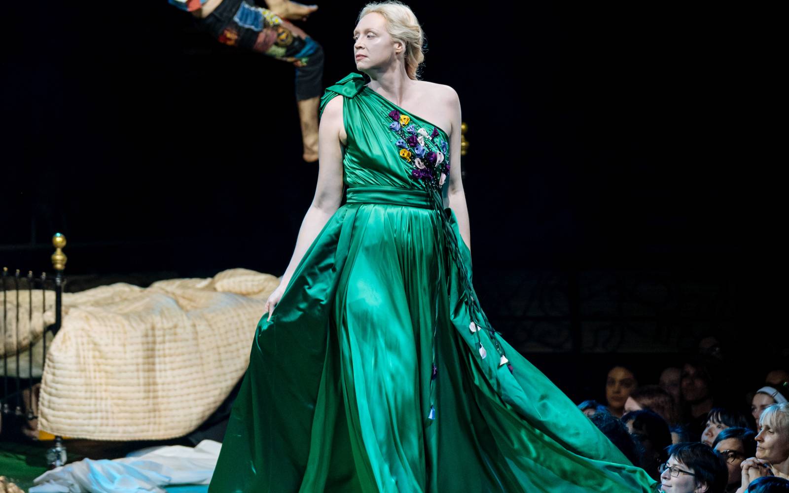 Gwendoline Christie (Hippolyta) strides forward, her emerald green dress billowing behind her