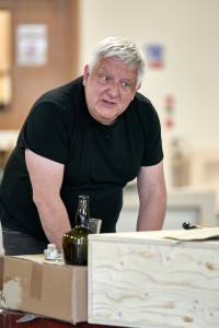 Photo of Simon Russell Beale leaning on table, his eyebrows are raised quite sternly like he's telling someone off.
