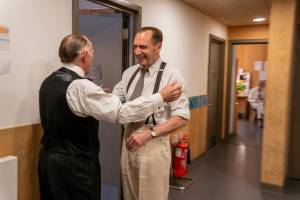Ralph Fiennes and Danny Webb embrace backstage.
