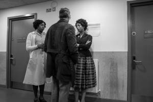 Dani Mosely, David Bromley and Alana Maria stand in the dressing room corridor in costume, talking.