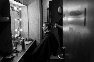 Samuel Barnett sits in his dressing room having his hair combed and gelled.