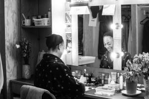 Alana Maria sits in her dressing room smiling.