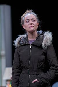 Sarah Twomey stands wearing a puffer jacket, she looks close to tears.