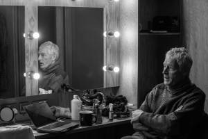 Michael Simkins sits backstage at a dressing table.