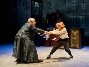 Simon Russell Beale and Lyndsey Marshal hold both hands and spin around in circle with childlike grins.