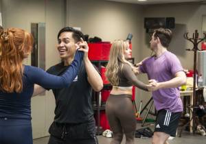 The cast of Guys & Dolls dancing with each other in rehearsals.