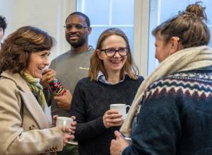 A small cluster of people in conversation, laughing and smiling.