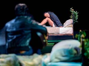 Hermia sits on a bed